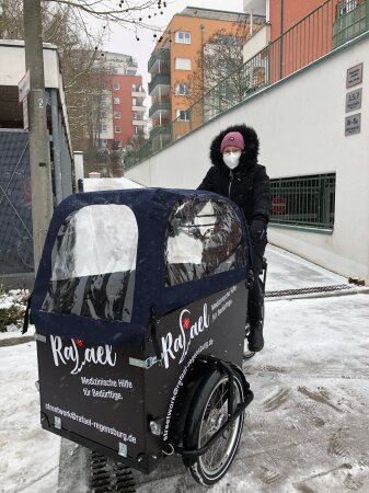 Frau sitzt auf einem Fahrradmobil für medizinische Hilfe