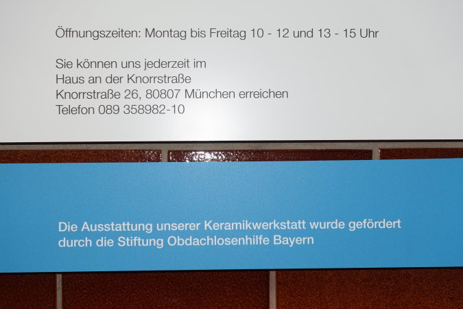 Schild des Werkladens mit Hinweis auf die Öffnungszeiten